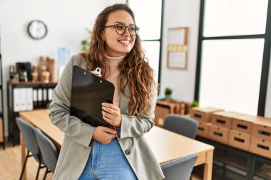 Genç, güzel, İspanyol bir kadın. İş işçisi. Elinde bir pano var.