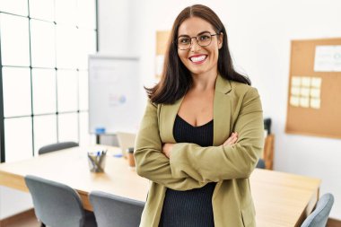 Genç, güzel, İspanyol bir iş adamı. Kendine güler yüzlü. Ofiste kollarını kavuşturmuş duruyor.