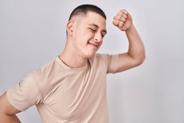 İzole edilmiş arka planda duran genç adam yorgun ve rahat, uykulu ve sabahın erken saatleri için esniyor. 