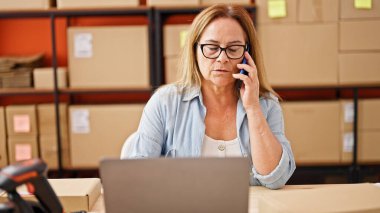 Orta yaşlı İspanyol kadın, iş adamı. Ofiste bilgisayarla konuşuyor.