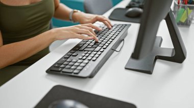 Genç sarışın iş kadını ofiste bilgisayar kullanıyor.