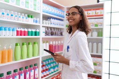 Young african american woman pharmacist using touchpad working at pharmacy