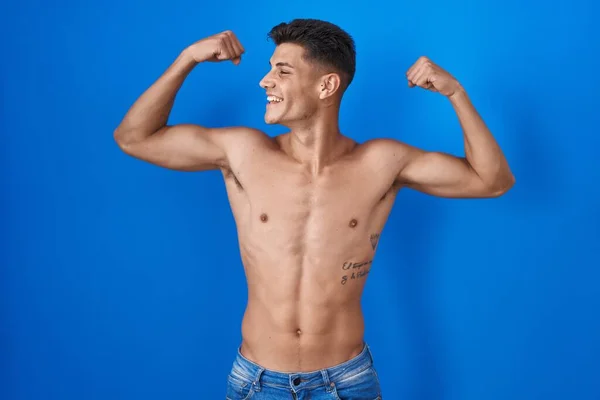 Junger Hispanischer Mann Steht Hemdlos Vor Blauem Hintergrund Und Zeigt — Stockfoto