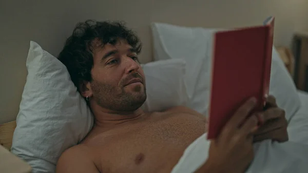 Young Hispanic Man Reading Book Lying Bed Bedroom — Stock Photo, Image