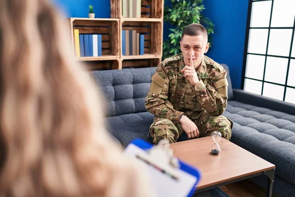 Young man doing therapy after war asking to be quiet with finger on lips. silence and secret concept.