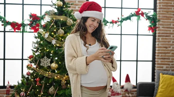 Młoda Ciężarna Kobieta Świętuje Boże Narodzenie Pomocą Smartfona Domu — Zdjęcie stockowe