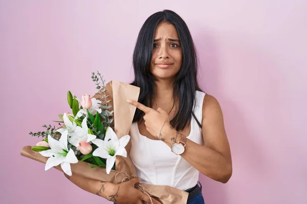 Mulher Morena Segurando Buquê Flores Brancas Apontando Para Lado Preocupado — Fotografia de Stock