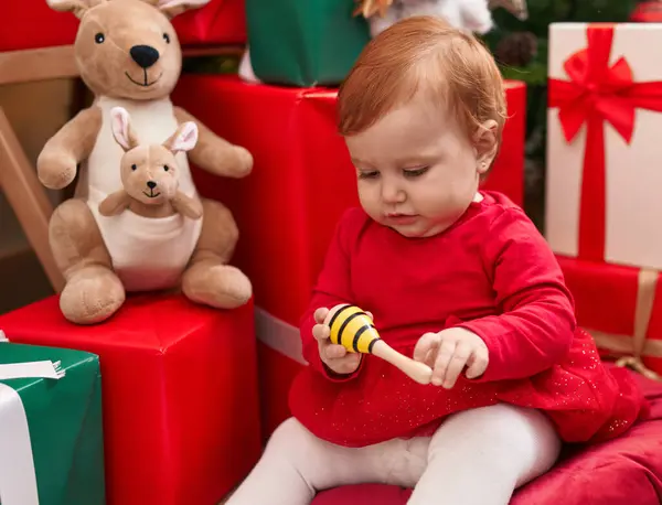 Maraca Kucağında Tutan Sevimli Kızıl Saçlı Bebek Evde Noel Hediyeleriyle — Stok fotoğraf