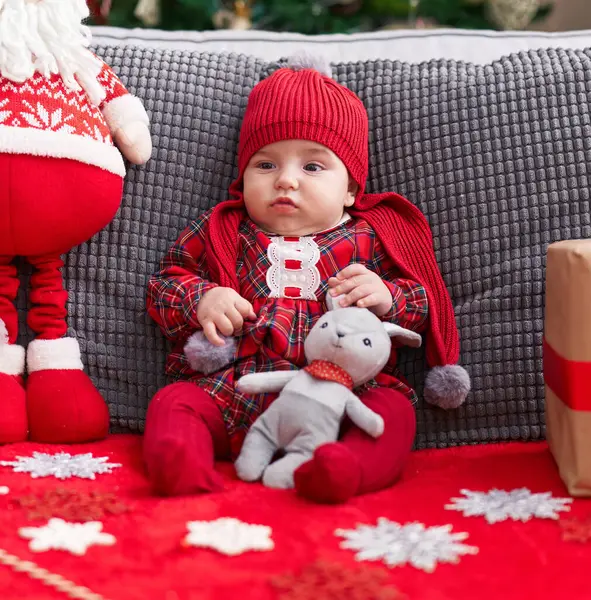 愛らしいですCaucasian赤ん坊保持テディベア座っています上のソファによってクリスマスツリーホーム — ストック写真