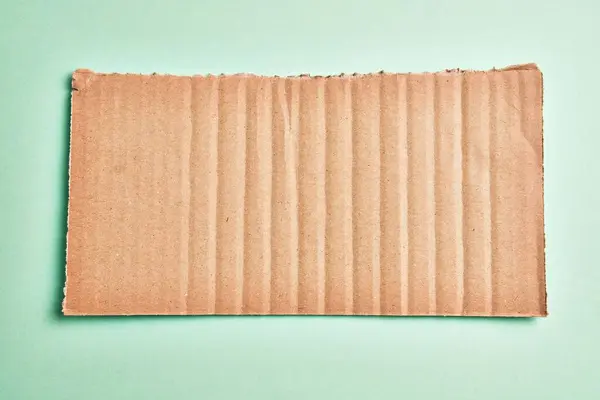 Zole Edilmiş Yeşil Arka Planda Bir Parça Karton Malzeme — Stok fotoğraf
