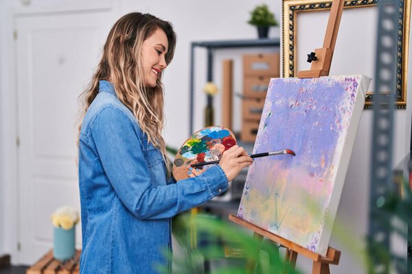 Young woman artist smiling confident drawing at art studio