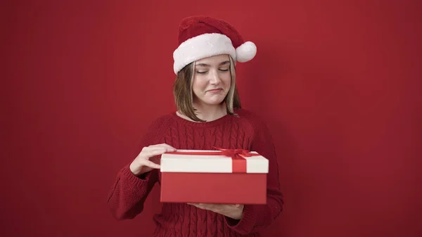Νεαρή Ξανθιά Γυναίκα Φοράει Χριστουγεννιάτικο Καπέλο Κρατώντας Δώρο Πάνω Από — Φωτογραφία Αρχείου