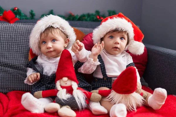 Kanepede Oturup Noel Baba Oyuncağıyla Oynayan Iki Sevimli Bebek — Stok fotoğraf