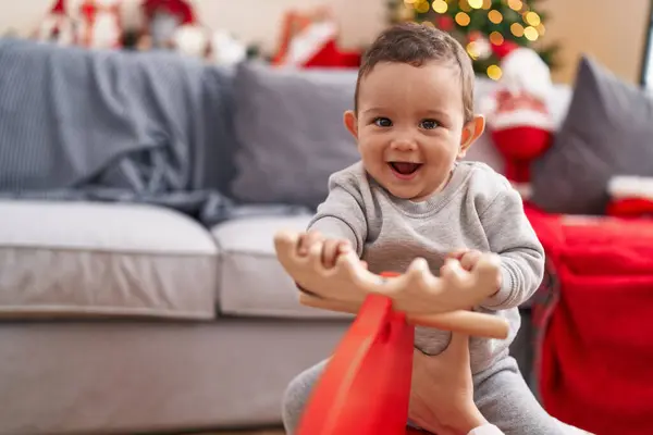 Adorable Hispanic Baby Playing Reindeer Rocking Christmas Tree Home — Stock Photo, Image