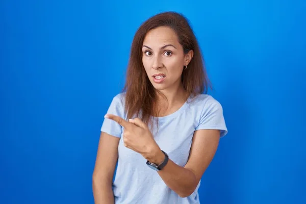 Brunette Woman Standing Blue Background Pointing Aside Worried Nervous Forefinger — Stock Photo, Image