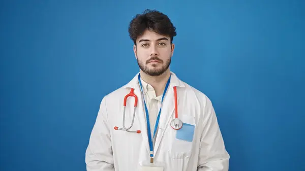 Dokter Muda Hispanik Berdiri Dengan Ekspresi Serius Atas Latar Belakang — Stok Foto
