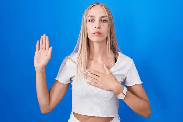 Young Caucasian Woman Standing Blue Background Swearing Hand Chest Open — Stockfoto
