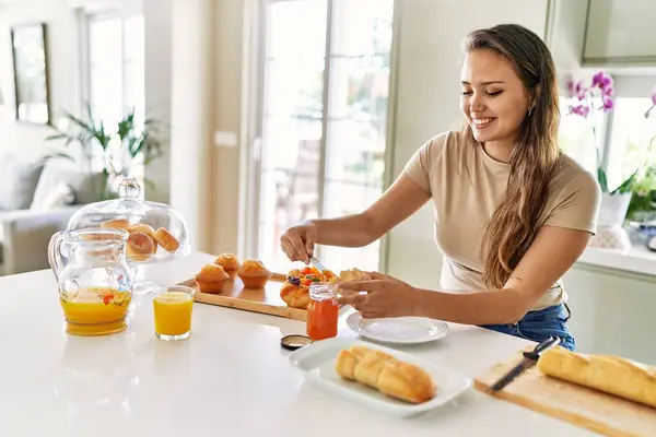 年轻美丽的惊慌失措的女人在厨房准备早餐 在面包上涂果酱 — 图库照片