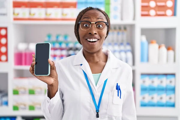 Eczanede Çalışan Afro Amerikalı Kadın Akıllı Telefon Ekranı Göstererek Şaşkınlık — Stok fotoğraf