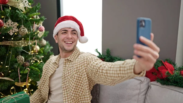 自宅でクリスマスプレゼントでセルフィーを取る若いヒスパニックの男 — ストック写真