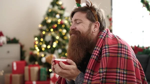 Ung Rödhårig Man Dricker Kaffe Sittandes Soffan Vid Julgranen Hemma — Stockfoto
