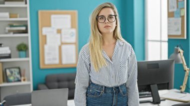 Ofiste ciddi yüzü olan genç sarışın bir iş kadını.