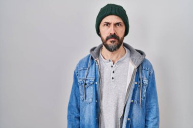 Dövmeli, yün şapkalı, yüzünde ciddi bir ifadeyle gevşemiş bir İspanyol. Basit ve doğal bir şekilde kameraya bakıyorsun.. 
