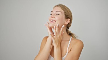 Genç sarışın kadın gülümsüyor kendine güveni tam beyaz arka planda.