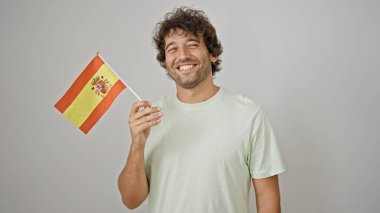 İspanyol genç adam gülümsüyor. İspanyol bayrağını izole edilmiş beyaz arka planda tutuyor.