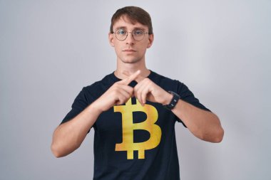 Beyaz, sarışın, bitcoin tişört giyen, reddedilmiş, negatif işaret veren bir adam. 