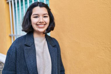 Young woman smiling confident looking to the camera at street