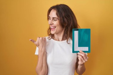 Güzel esmer kadın, elinde tutuyor. Yeni şoför için imzalıyorum. Başparmağımı kaldırıp gülümsüyorum. 