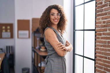 Genç, güzel, İspanyol bir iş adamı. Kendine güler yüzlü. Ofiste kollarını kavuşturmuş duruyor.
