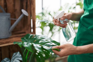 Çiçekçide çalışan sarışın bir çiçekçi.