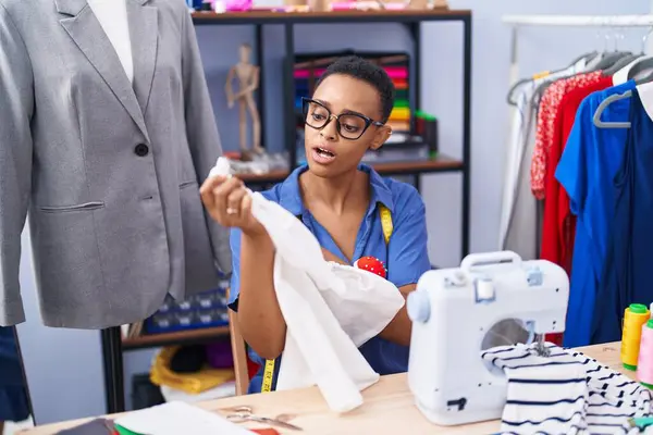 African american woman tailor holding t shirt at tailor shop