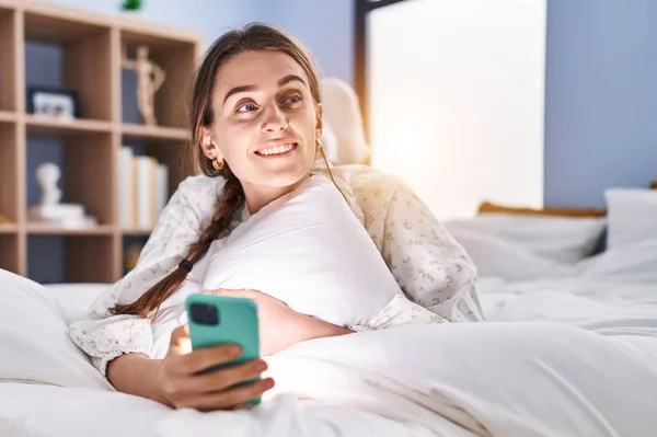 Νεαρή Καυκάσια Γυναίκα Που Χρησιμοποιεί Smartphone Ξαπλωμένη Στο Κρεβάτι Στο — Φωτογραφία Αρχείου