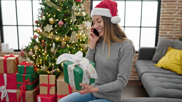 Mladá Běloška Žena Drží Vánoční Dárek Mluvit Smartphone Doma — Stock fotografie