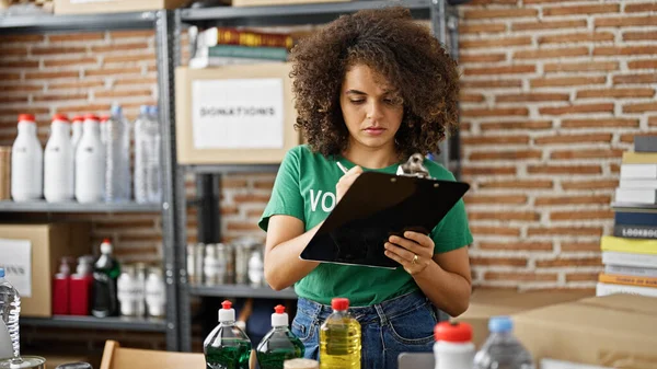 Young Beautiful Hispanic Woman Volunteer Writing Document Checking Products Charity — Stock Photo, Image