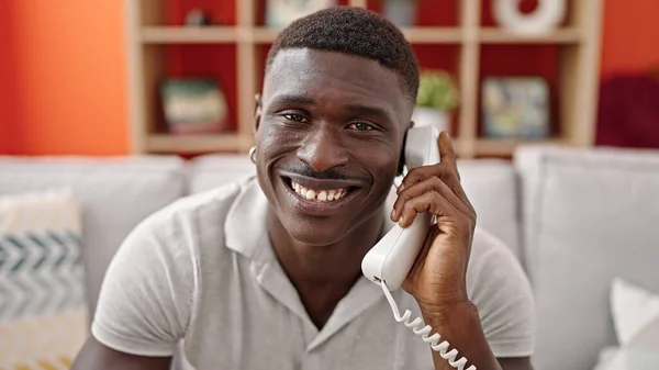 Hombre Afroamericano Hablando Por Teléfono Sentado Sofá Sonriendo Casa —  Fotos de Stock