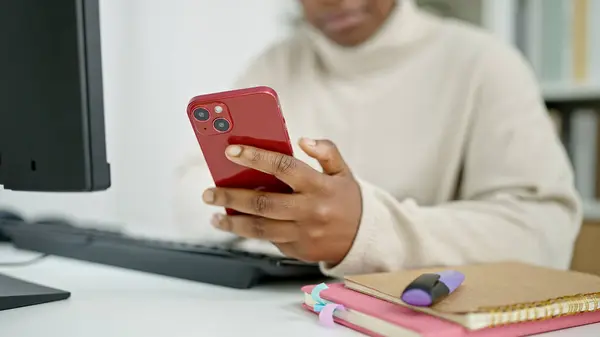 stock image African american woman student using computer and smartphone at library university