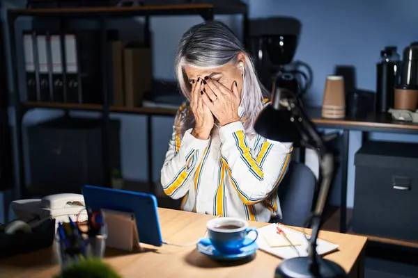 夜にオフィスで働く灰色の髪を持つ中年の女性は 泣きながら手で顔を覆う悲しい表情をしています うつ病コンセプト — ストック写真
