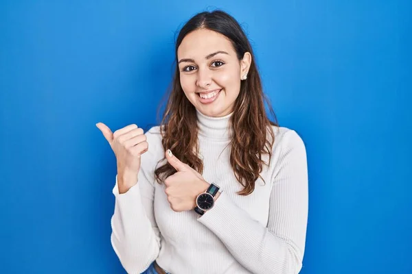 Young Hispanic Woman Standing Blue Background Pointing Back Hand Thumbs — Stock Photo, Image