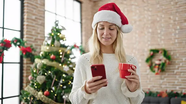 Mladá Blondýna Žena Slaví Vánoce Pomocí Smartphone Pití Kávy Doma — Stock fotografie