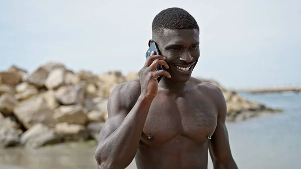 非洲裔美国人游客赤身裸体站在海滩上用智能手机交谈 — 图库照片