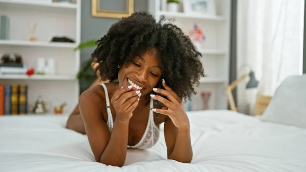 Afroamerykanka Mówi Smartfonie Leżącym Łóżku Seksownie Wyglądającym Sypialni — Zdjęcie stockowe