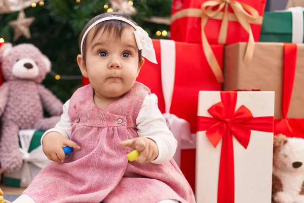 Adorable Hispanic Baby Holding Hoops Toy Sitting Floor Christmas Tree — Stock Photo, Image