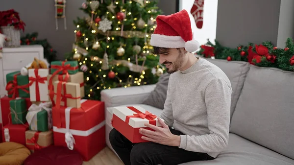 Young Hispanic Man Smiling Confident Holding Christmas Gift Home — ストック写真