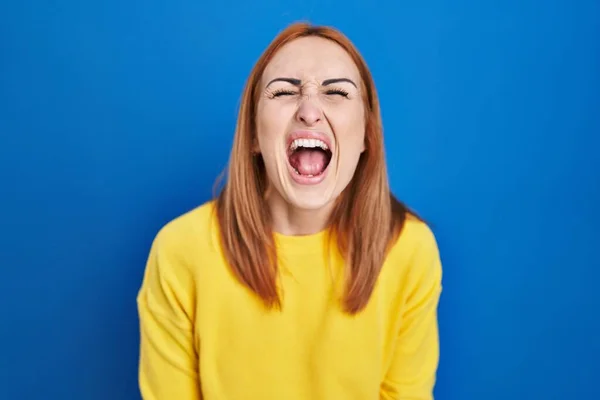 Young Woman Standing Blue Background Angry Mad Screaming Frustrated Furious — Stok fotoğraf