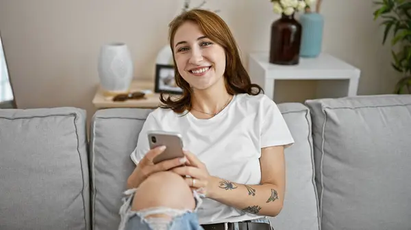 Jonge Vrouw Met Behulp Van Smartphone Zittend Bank Thuis — Stockfoto