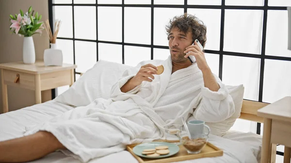 Young Hispanic Man Having Breakfast Talking Smartphone Bedroom — Stock Photo, Image